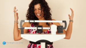 Woman happy while weighing herself on the scale