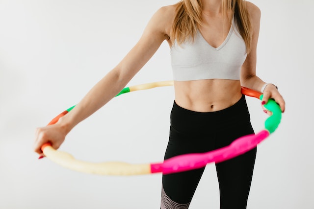 Fit woman exercising with a hula hoop