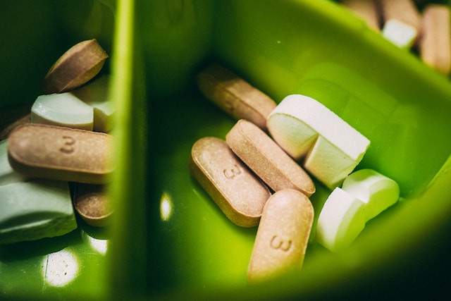 Bowl of supplements and anti inflammatories.