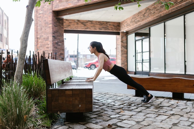 Woman doing elevated push ups on a bench