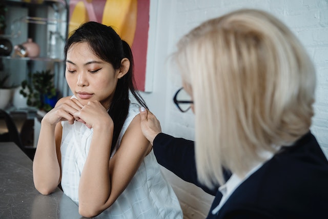 Young woman being comforted by a therapist for post-surgery anxiety
