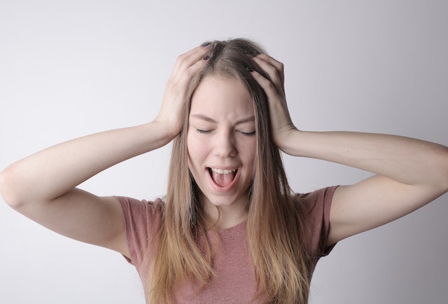 Young woman screaming with closed eyes after changing behavior